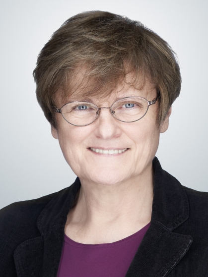 Katalin Kariko Brown hair, glasses, purple shirt black blazer