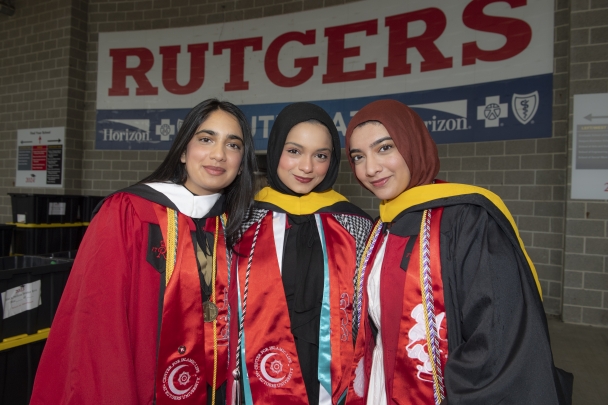 Hana Patel (School of Arts and Sciences), Hiba Shahid (School of Arts and Sciences and Bloustein School) and Libah Farooqi (Rutgers Business School) celebrate in the assembly area at the 258th anniversary commencement ceremonies for Rutgers University–New Brunswick and Rutgers Health class of 2024.